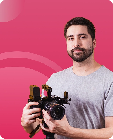 Image depicting a person holding a camera with video equipment against a pink background, representing text reader tools for content creators.