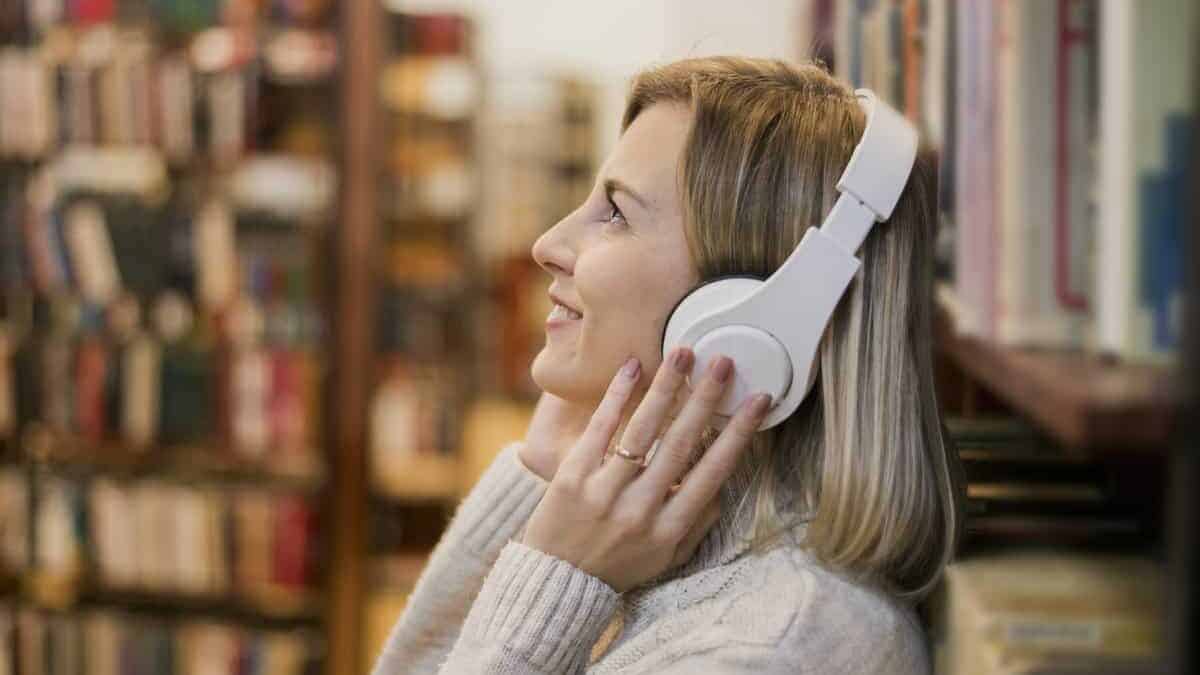 wanita mendengar buku audio di perpustakaan